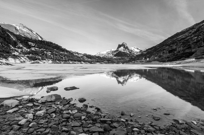 Monochrome mountain lake reflection in winter