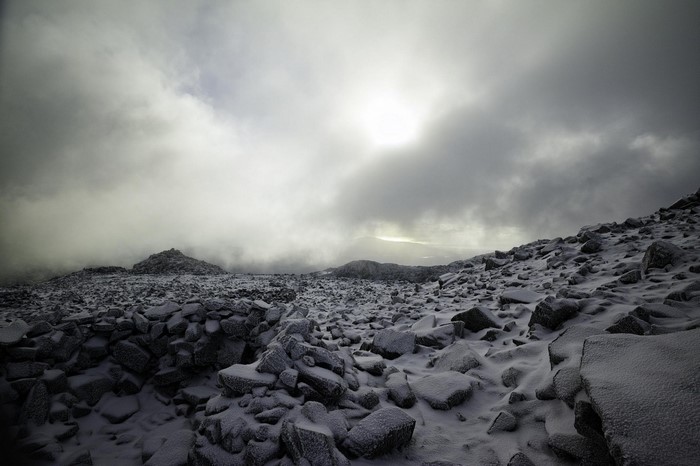 Snowy rocky landscape under cloudy sky
