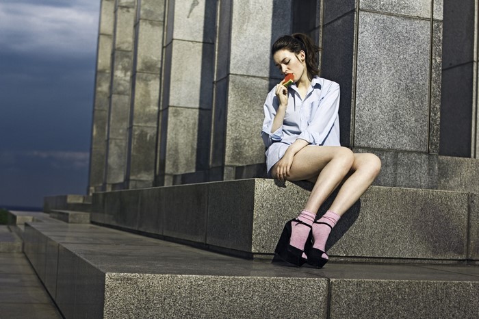 Woman eating watermelon on stone steps