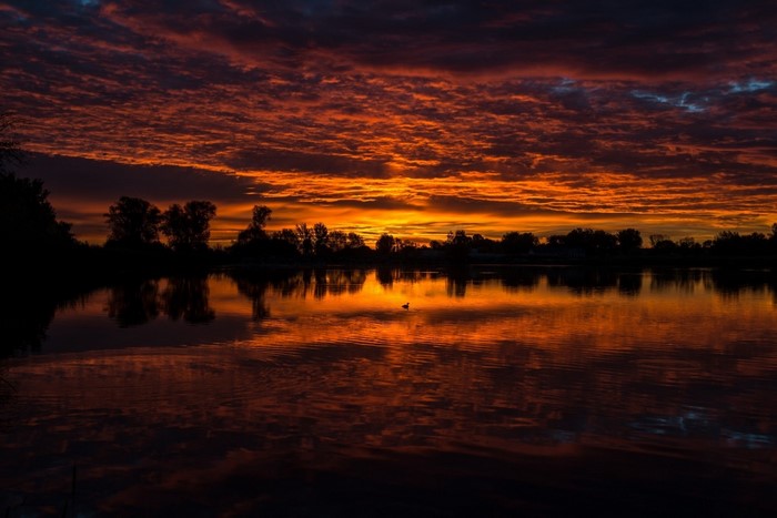 Sunset over a lake with reflections and clouds