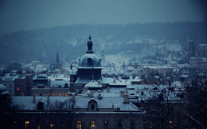 Snowy cityscape with domes and towers at dusk
