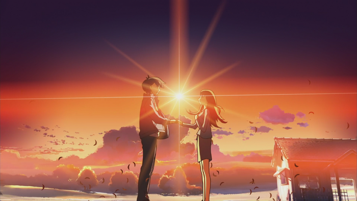 Couple holding hands at sunset with sun flare