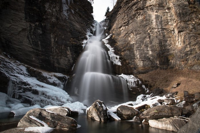 Waterfall cascading over rocks with ice formations