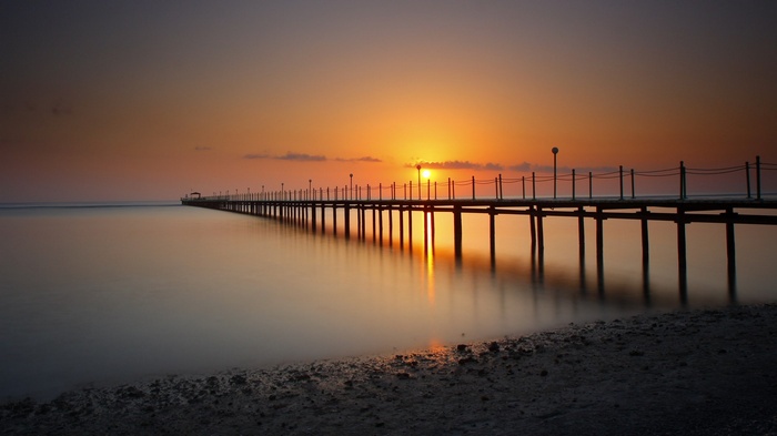 Pier at sunset over calm water