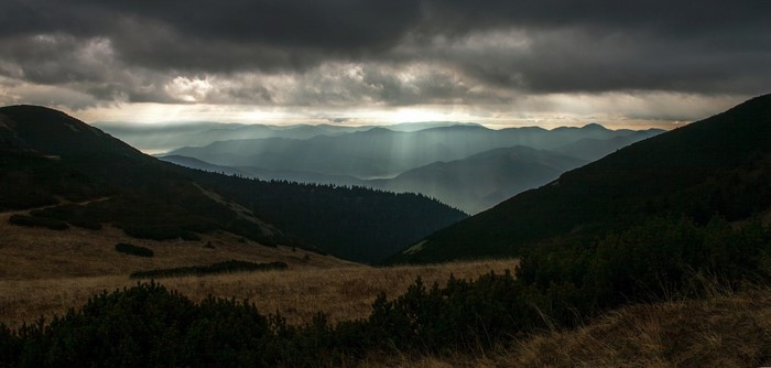 Mountain range with sunbeams through clouds