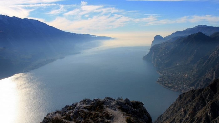 Lake surrounded by mountains under a cloudy sky