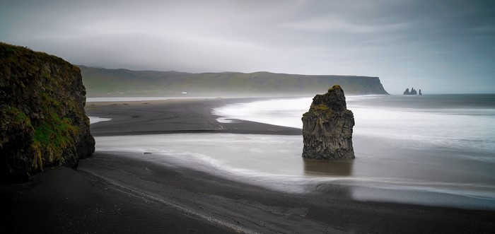 Black sand beach with sea stacks and cliffs