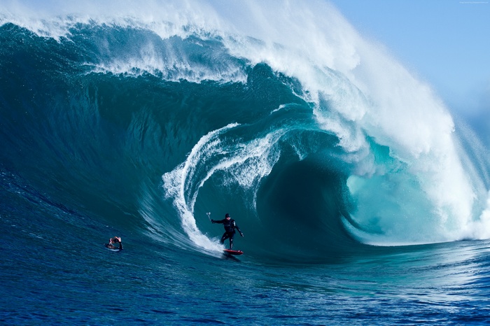 Surfer riding a massive wave in the ocean