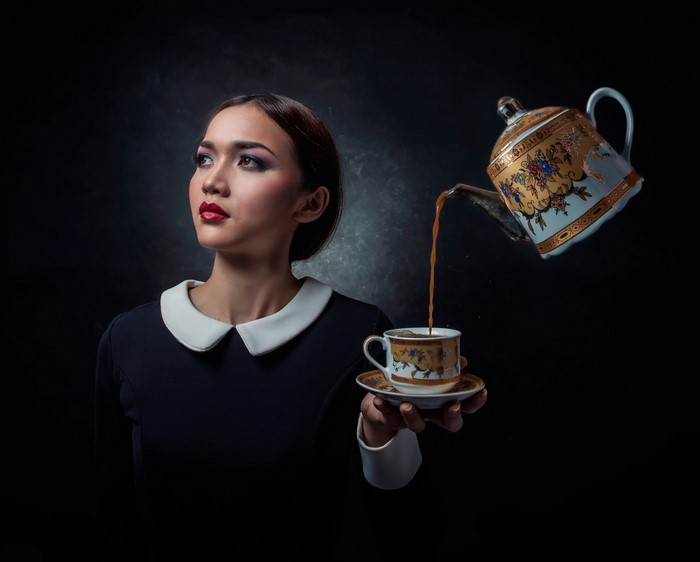 Woman pouring tea from a floating teapot