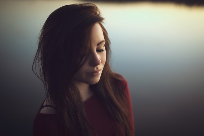 Woman with long brown hair and closed eyes