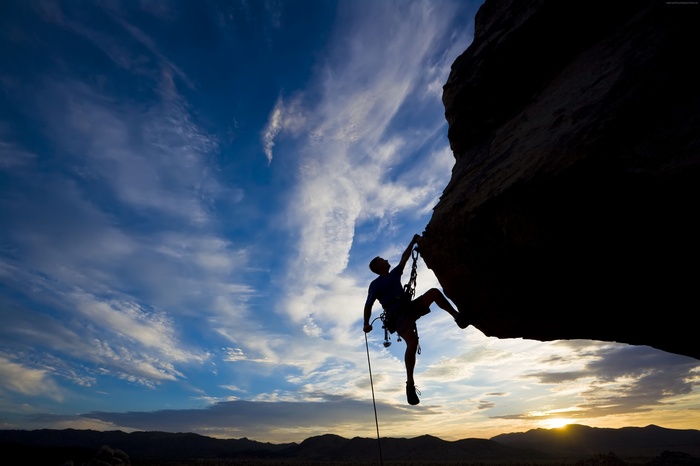 Silhouette of a rock climber at sunset