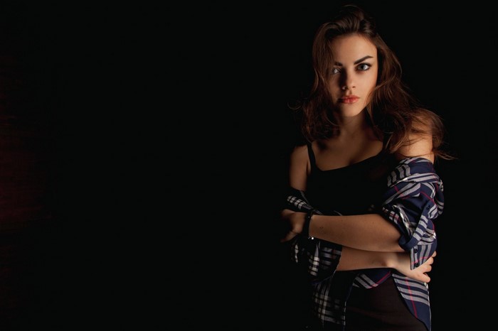 Woman with arms crossed wearing a plaid shirt