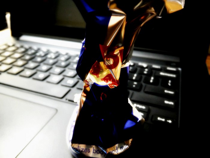 Crumpled Red Bull can on a laptop keyboard