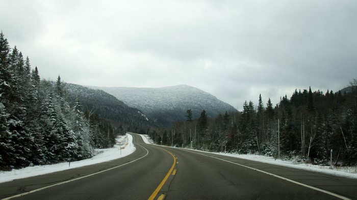Winding mountain road through a snowy forest