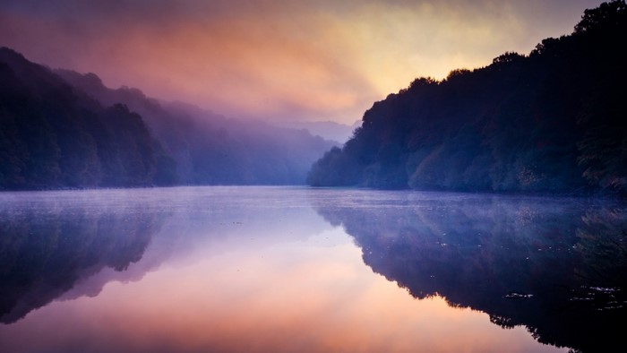 Misty lake at sunrise with colorful sky and reflections