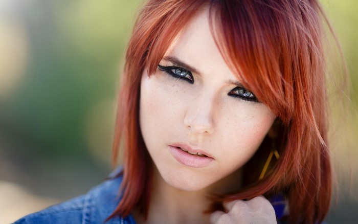 Close-up portrait of a young woman with red hair