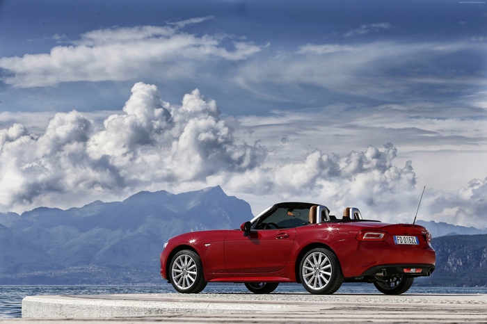 Red FIAT 124 Spider roadster by the water