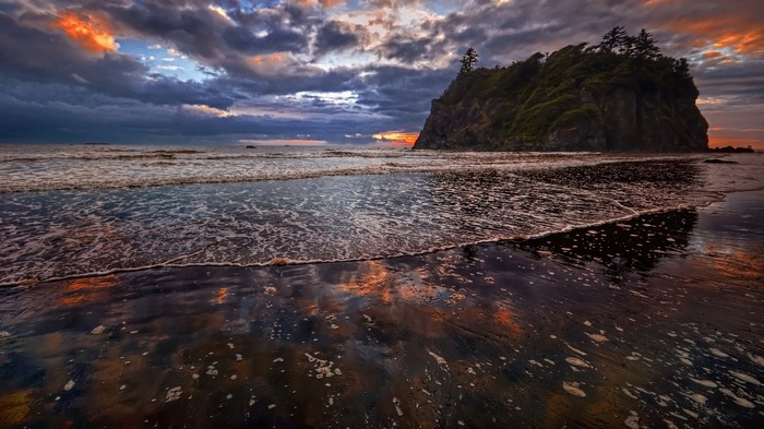 Dramatic sunset over a rocky island and beach