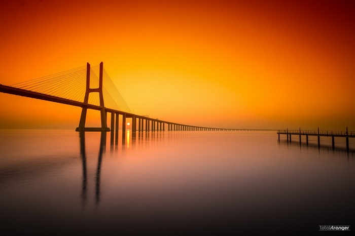 Vasco da Gama Bridge at sunset over water