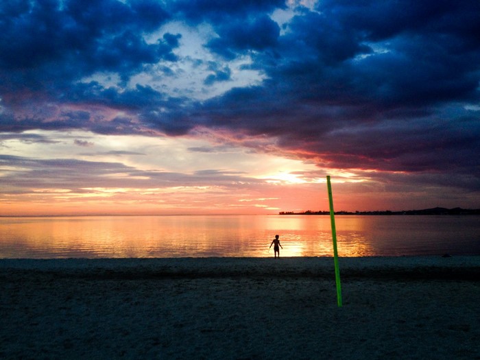 Silhouette of a child on a beach at sunset