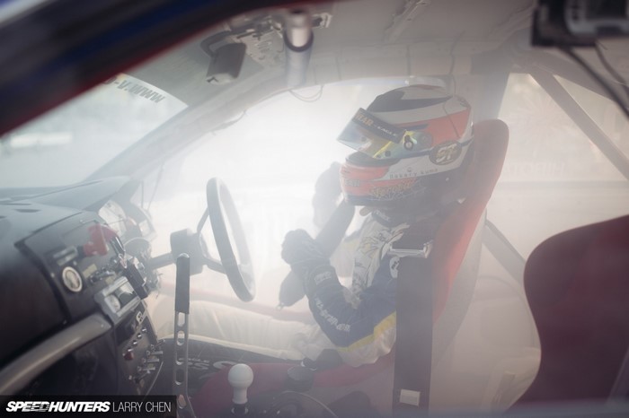 Drifting race car interior with driver in helmet