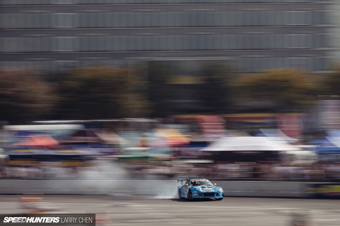 Blue drift car on a race track with spectators