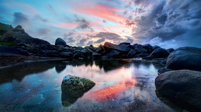 Rocky shore with calm water and colorful sky