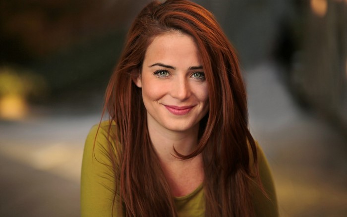 Smiling Redhead Woman with Long Hair in Soft Light