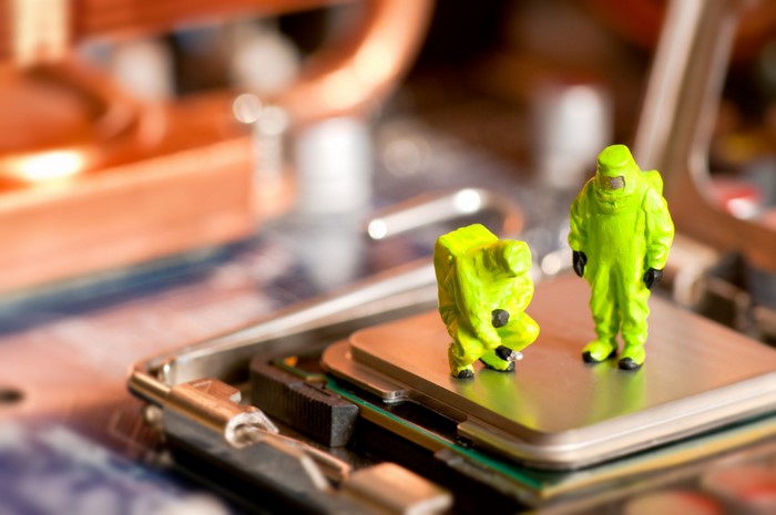 Miniature figures in hazmat suits on computer motherboard