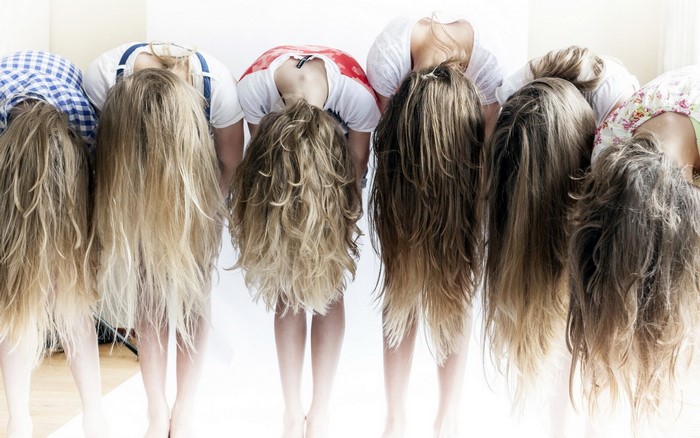 Group of women with long hair bent over