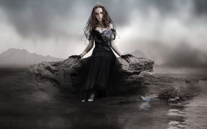 Woman in black dress on a rock in the water