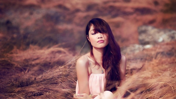 Woman with eyes closed in a field