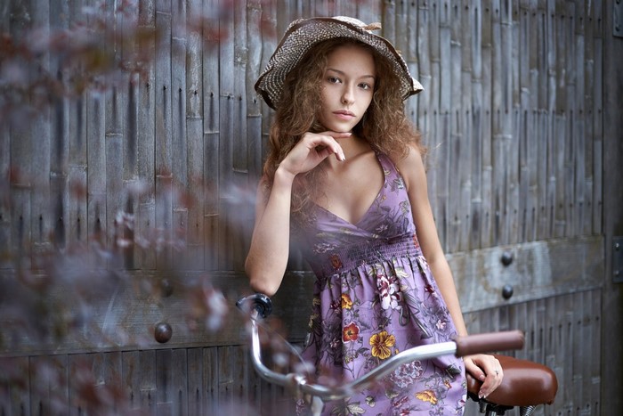 Woman in a floral dress and hat with a bicycle