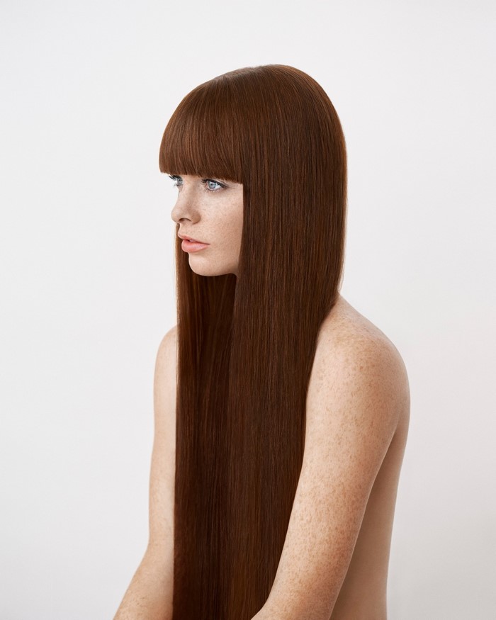 Woman with long auburn hair and bangs