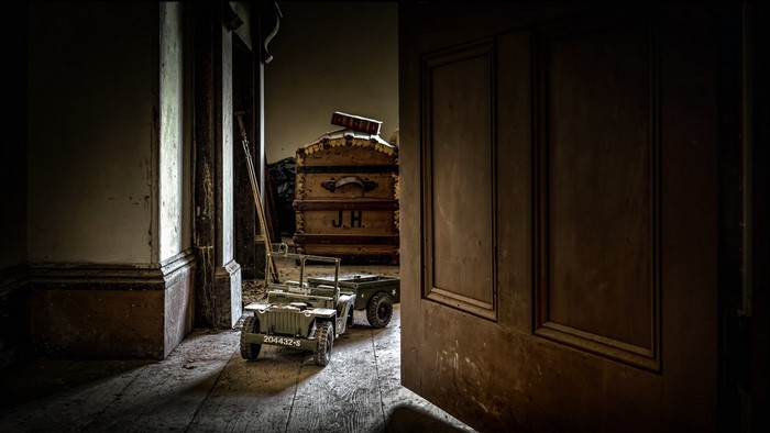 Toy jeep and trailer in a dark, abandoned room