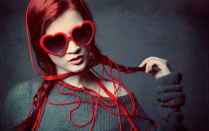 Woman with red hair and heart-shaped sunglasses