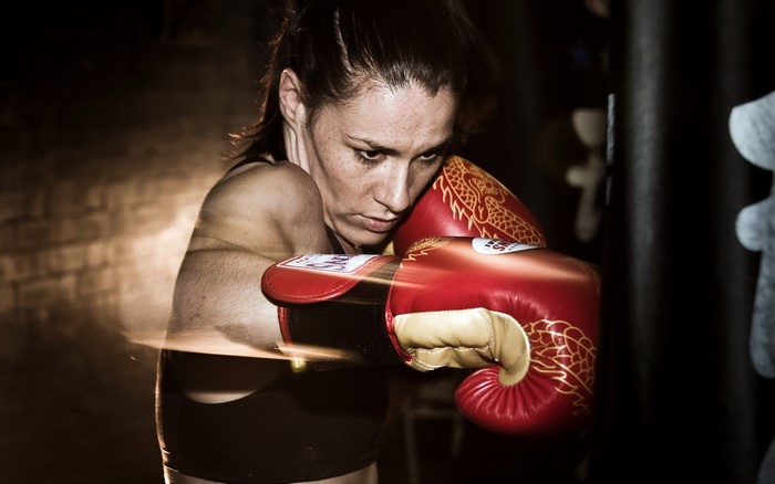 Woman in red boxing gloves training