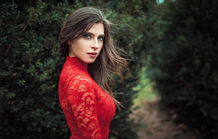 Woman in red lace dress in a forest