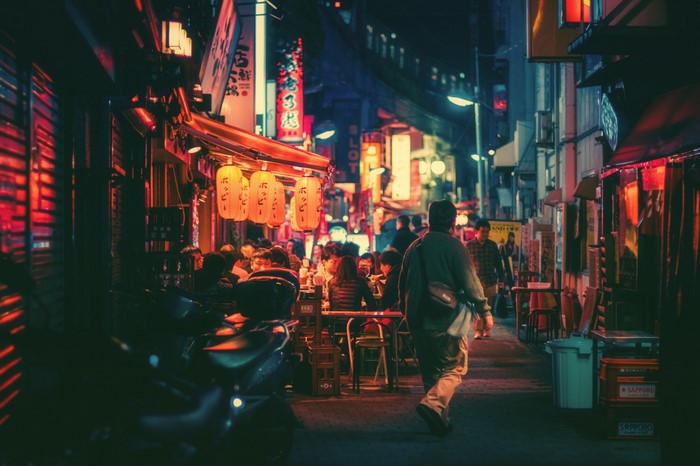 People dining at a street food stall in Japan at night