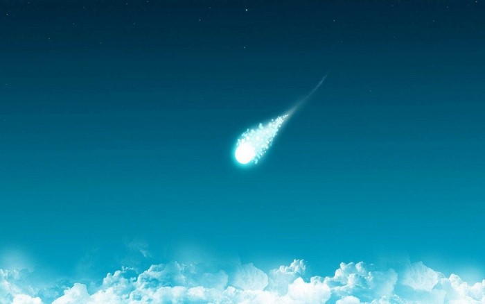 A comet streaks across a starry night sky above clouds
