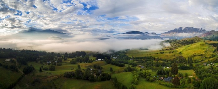 Misty valley with mountains and green fields in New Zealand