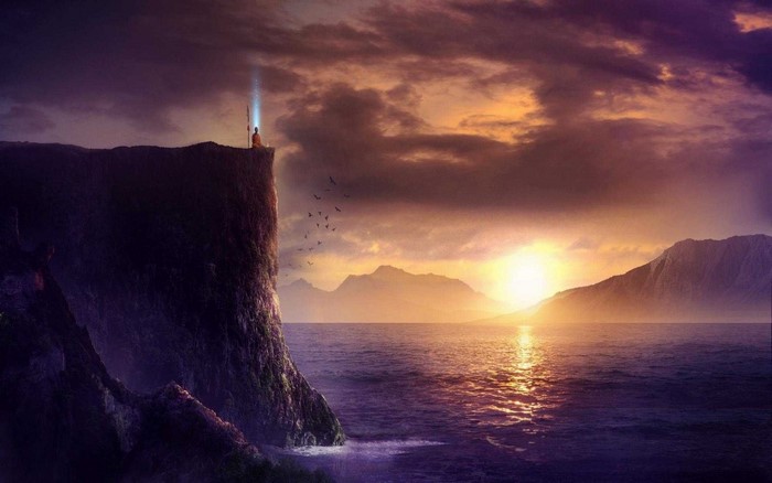 Monk meditating on cliff with light beam at sunset over ocean