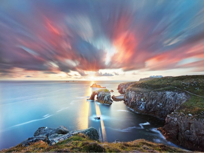 Sunset over rocky coast with sea arch
