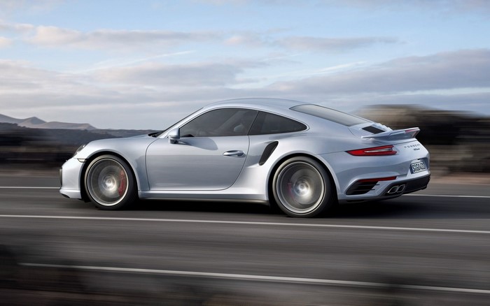 Silver Porsche 911 Turbo S driving on a road