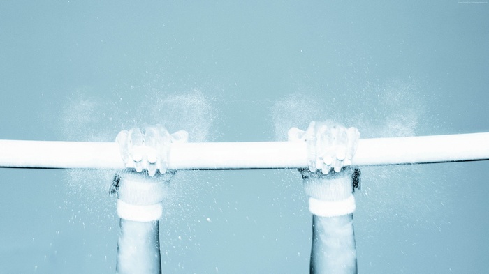 Hands gripping a pipe with water spraying