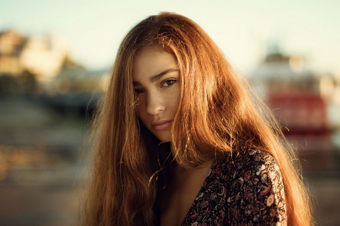 Young woman with long auburn hair in a floral dress