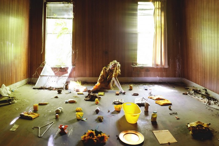 Woman sitting in a cluttered abandoned room