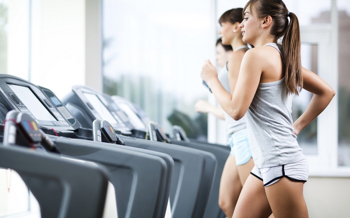 Women running on treadmills in a gym