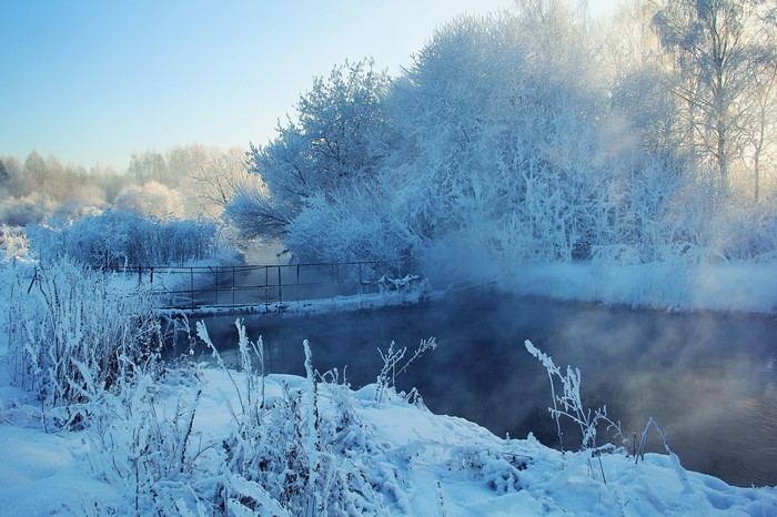 Winter landscape with a frozen river and mist