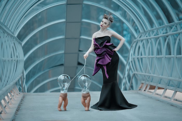 Woman in black dress walking lightbulb creatures